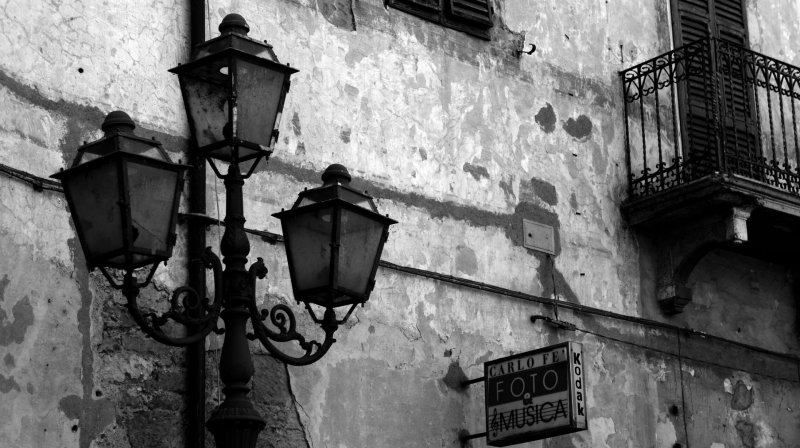 Itália Pitigliano Toscana janela sacada luminaria lâmpada luz comercio loja foto fotografia parede fachada