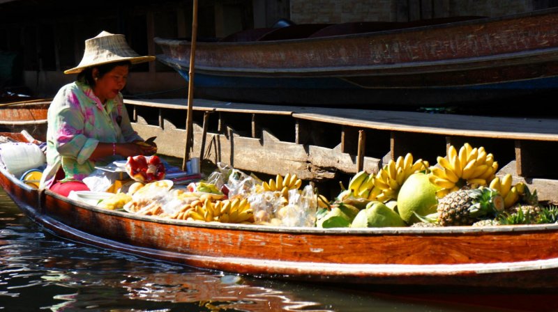 Mulher tailandesa em Taling Chan Floating Market Banguecoque Mercado flutuante Bangkok Tailândia exótico flutuar bens barco negócio palha vila economia comer comércio povos  vegetais mercado alimento turista  Ásia tradicional rural cultura asiática turismo  banguecoque transporte chapéu venda rio local étnico tailândia thai frutas banana abacaxi mercado flutuante